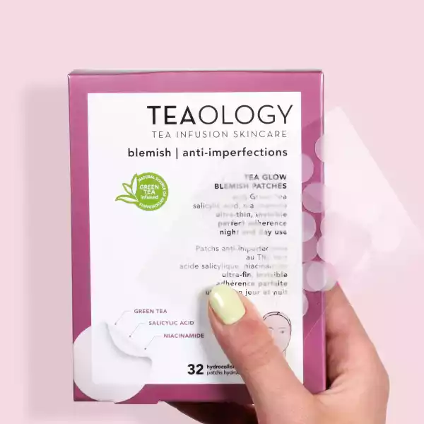 Eine Hand hält eine rosa Schachtel 'TEAOLOGY Tea Infusion Skincare' mit 32 Anti-Unreinheiten-Pflastern.